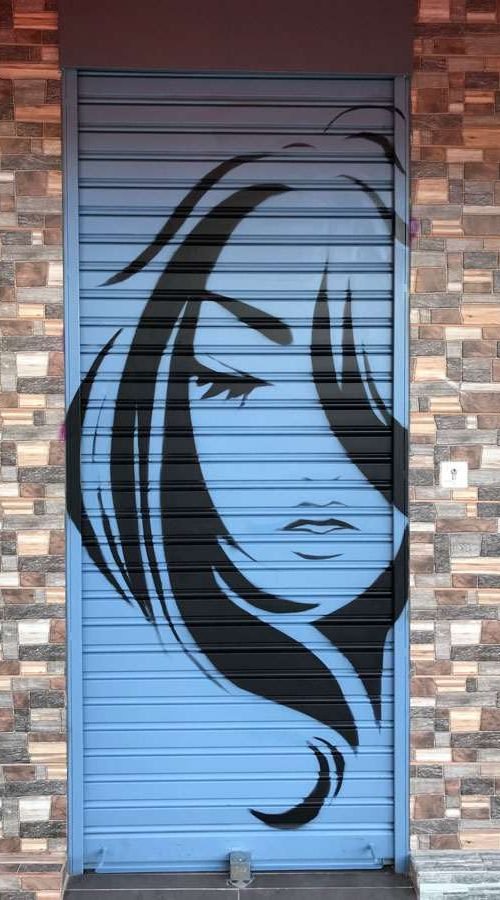 Murales urbano en salón Nails & Barber con silueta femenina y mano tatuada en tonos púrpura