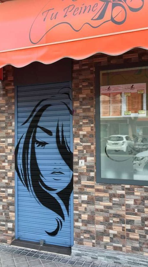 Murales urbano en salón Nails & Barber con silueta femenina y mano tatuada en tonos púrpura