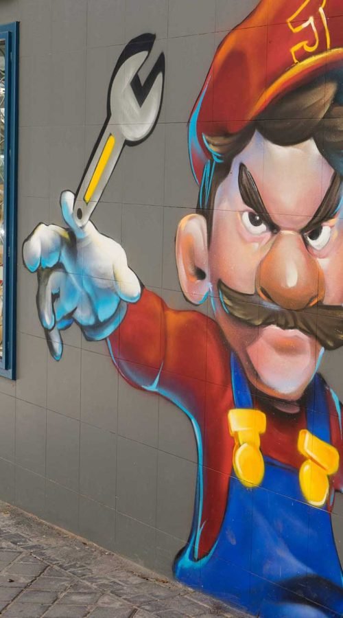 Mural para fontanería con personaje tipo Mario y herramientas, arte urbano comercial