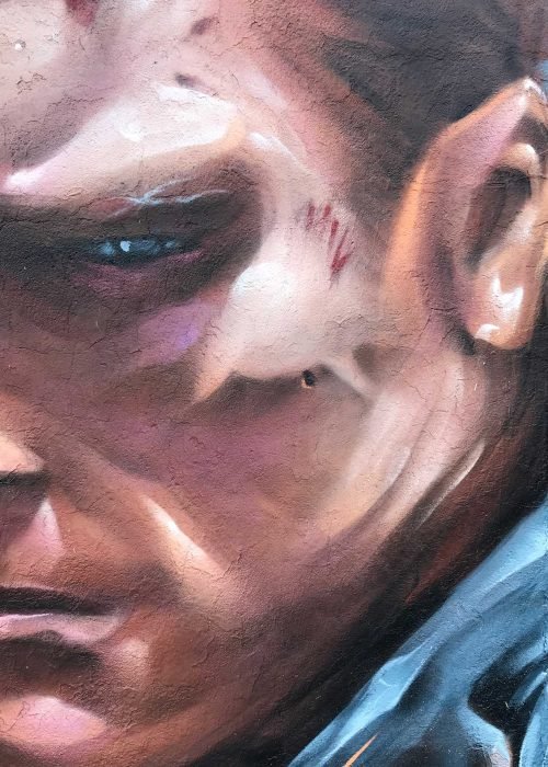 Graffiti hiperrealista de Terminator sobre fondo naranja y azul