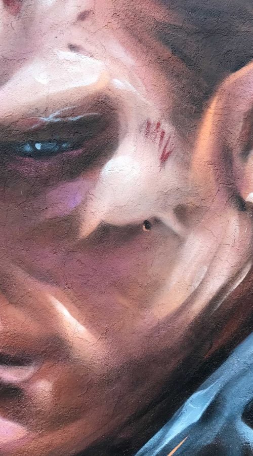 Graffiti hiperrealista de Terminator sobre fondo naranja y azul