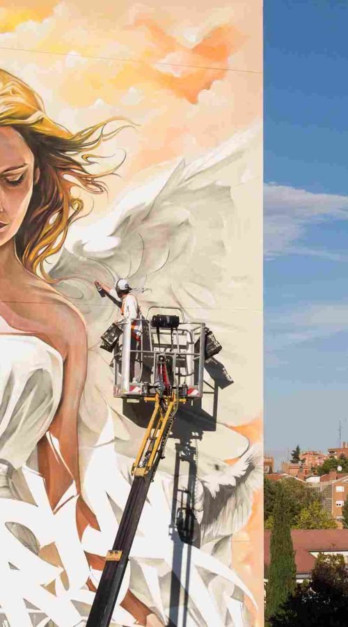 Muralistas corporativos trabajando en fachada de gran formato con plataformas elevadoras y medidas de seguridad PRL