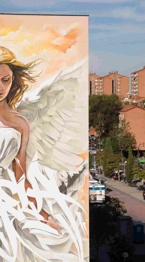 Mural institucional con ángel y lettering graffiti en fachada pública de Madrid