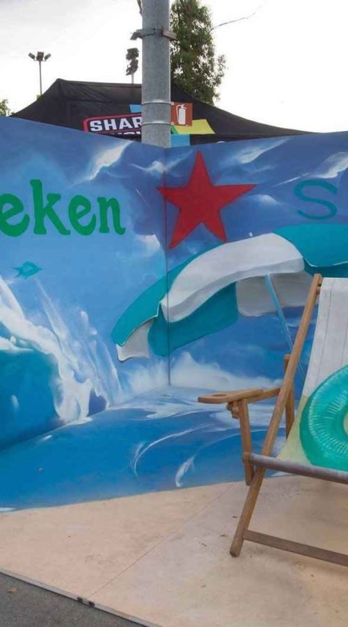 Mural para festival corporativo en Madrid para Heineken Silver con artista trabajando el paisaje marino del photocall