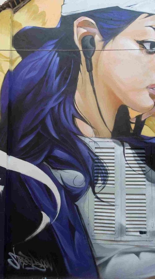 Mural graffiti en fachada de Camboya, retrato femenino con gorra para S’art Urban Art Festival.