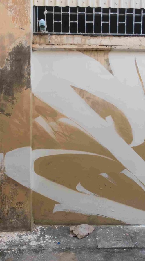 Mural graffiti en fachada de Camboya, retrato femenino con gorra para S’art Urban Art Festival.