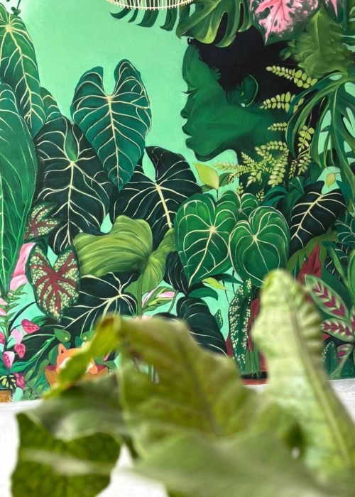 Mural graffiti de plantas en Cantabria con follaje tropical y perfil femenino en interior comercial