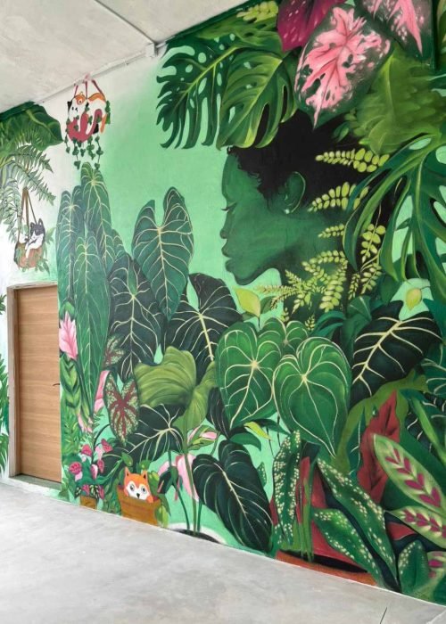 Mural decorativo para Plantukas en Cantabria con retrato femenino rodeado de hojas tropicales