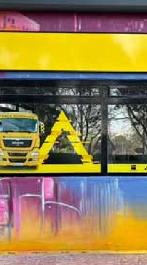 Mural con coches y motos en fachada de Autoescuelas Gala en Móstoles