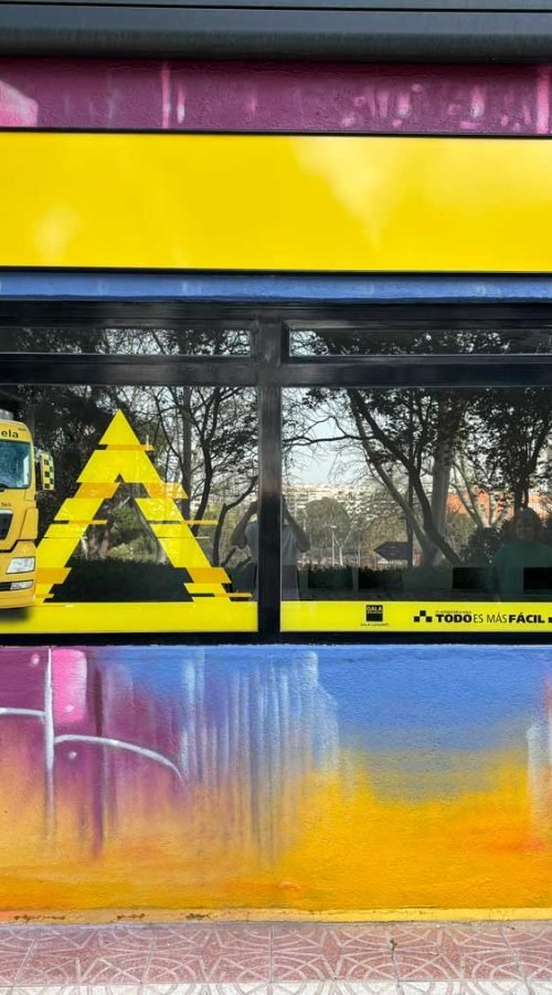 Mural con coches y motos en fachada de Autoescuelas Gala en Móstoles