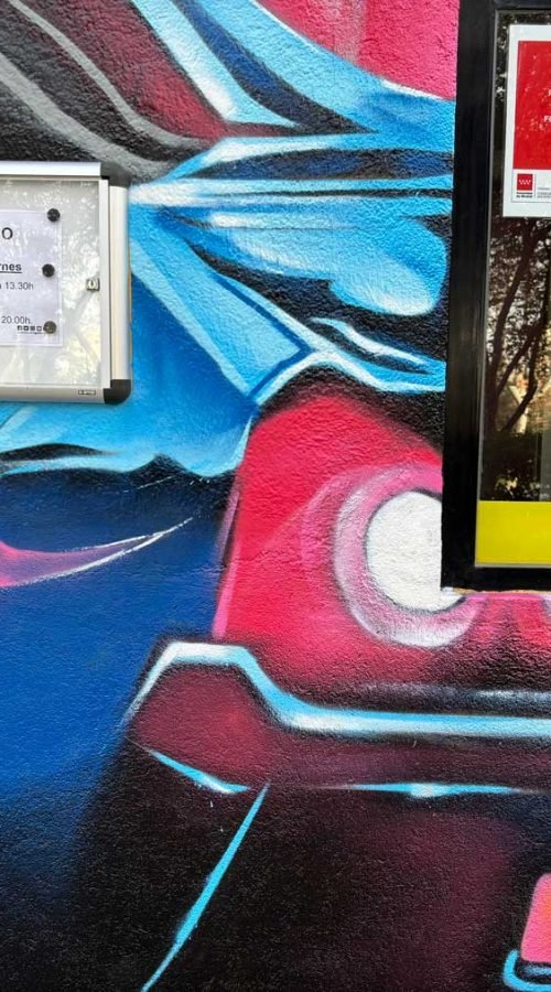 Mural con coches y motos en fachada de Autoescuelas Gala en Móstoles