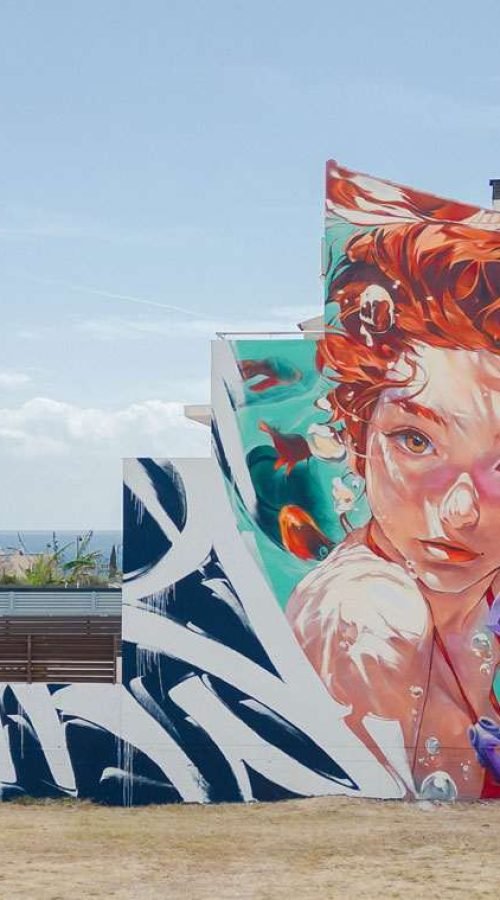 Graffiti de La Sirenita en fachada pública de L’Ametlla del Mar , Cataluña