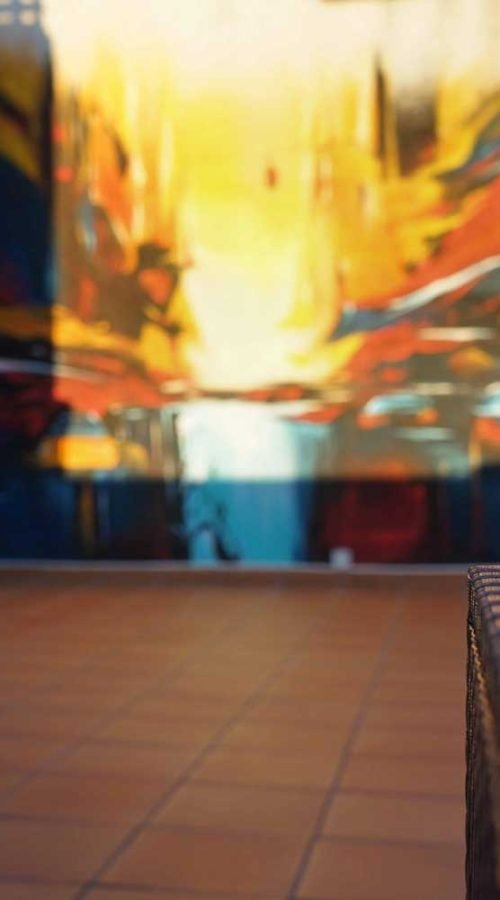 Mural artístico en terraza privada con siluetas y paisajes cálidos