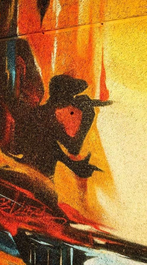 Mural artístico en terraza privada con siluetas y paisajes cálidos