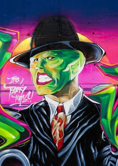 Mural de La Máscara estilo graffiti con fondo rosa y verde