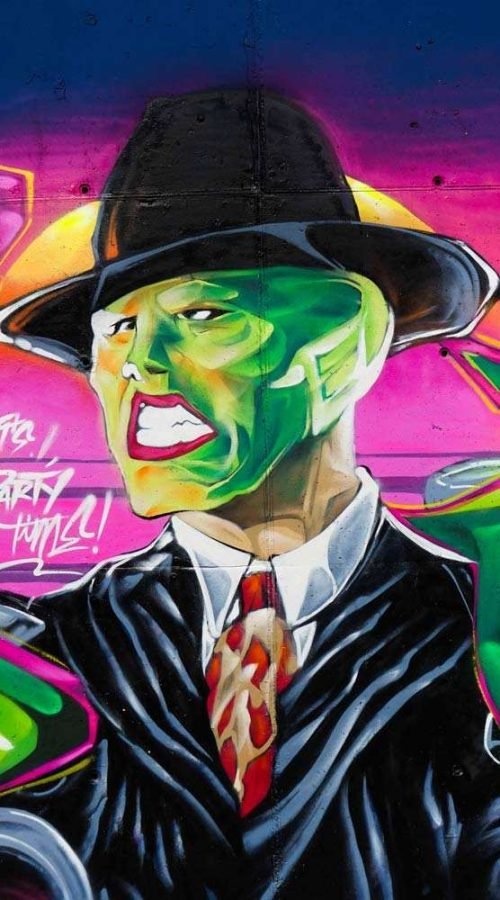 Mural de La Máscara estilo graffiti con fondo rosa y verde