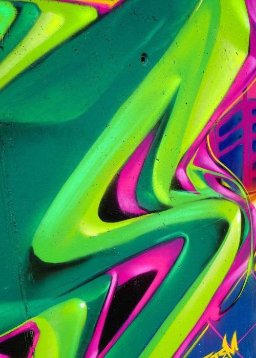 Mural de La Máscara estilo graffiti con fondo rosa y verde