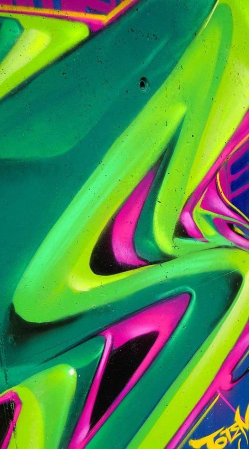 Mural de La Máscara estilo graffiti con fondo rosa y verde