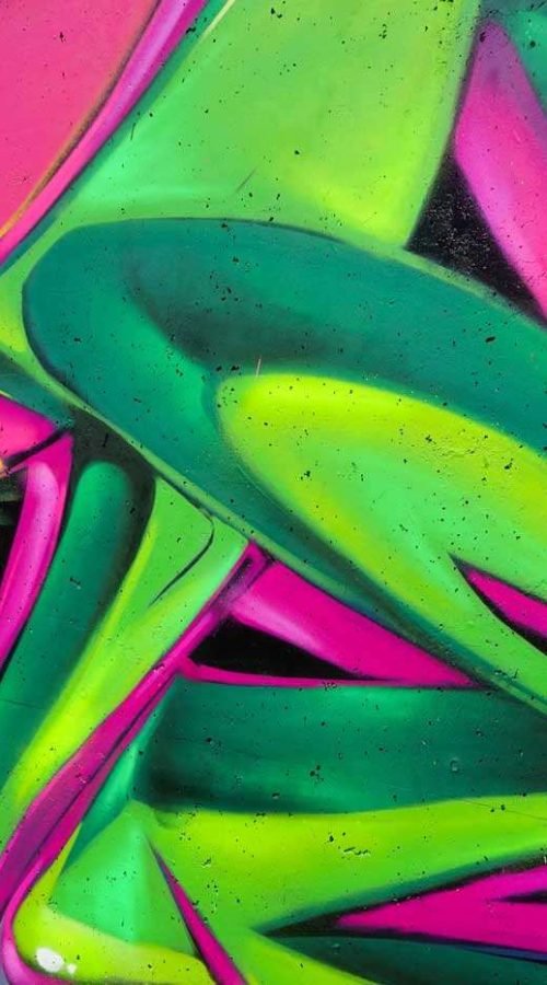 Mural de La Máscara estilo graffiti con fondo rosa y verde