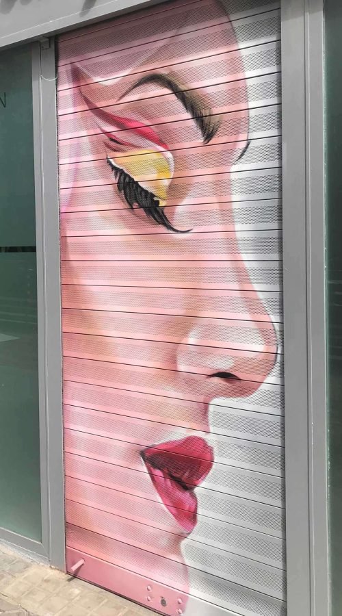 Retrato femenino en cierre de clínica Carmela Dávila, mural artístico para negocio de belleza