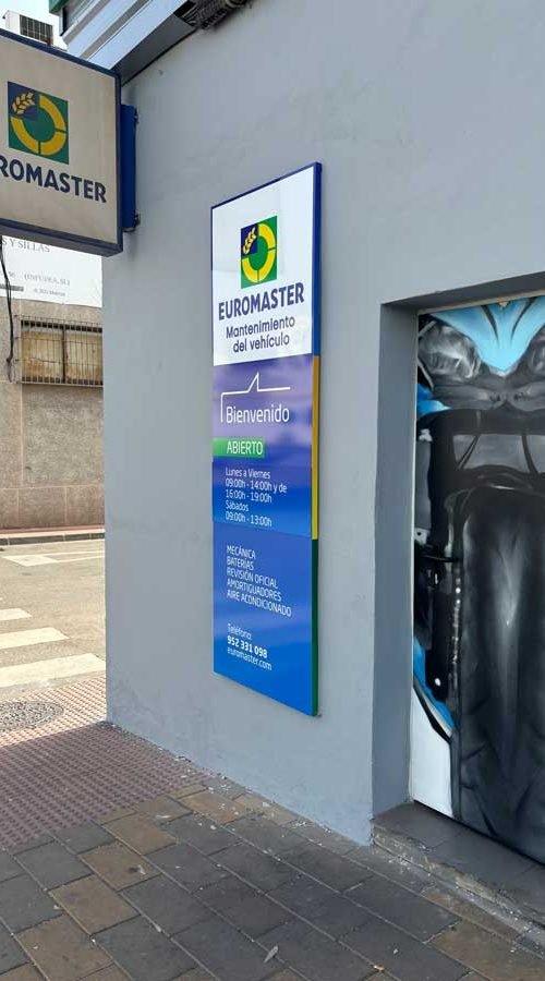 Mural de manos apretando tuerca en taller Euromaster Málaga