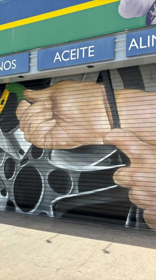 Mural de manos apretando tuerca en taller Euromaster Málaga