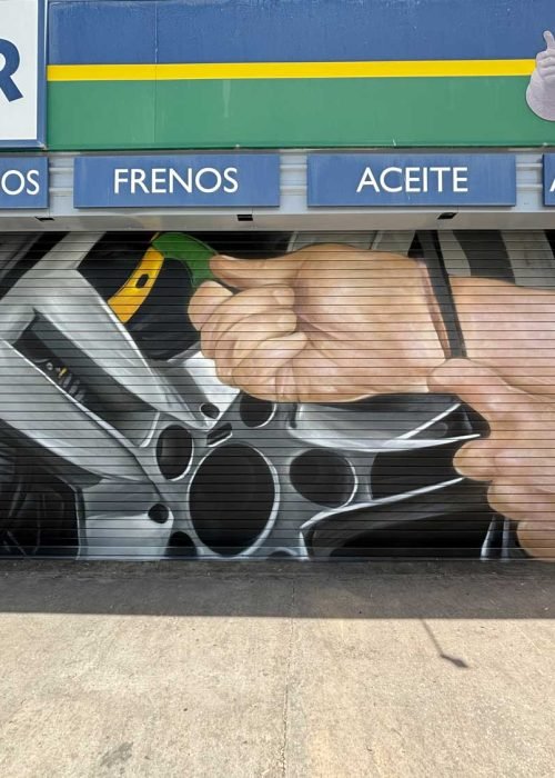 Mural de manos apretando tuerca en taller Euromaster Málaga