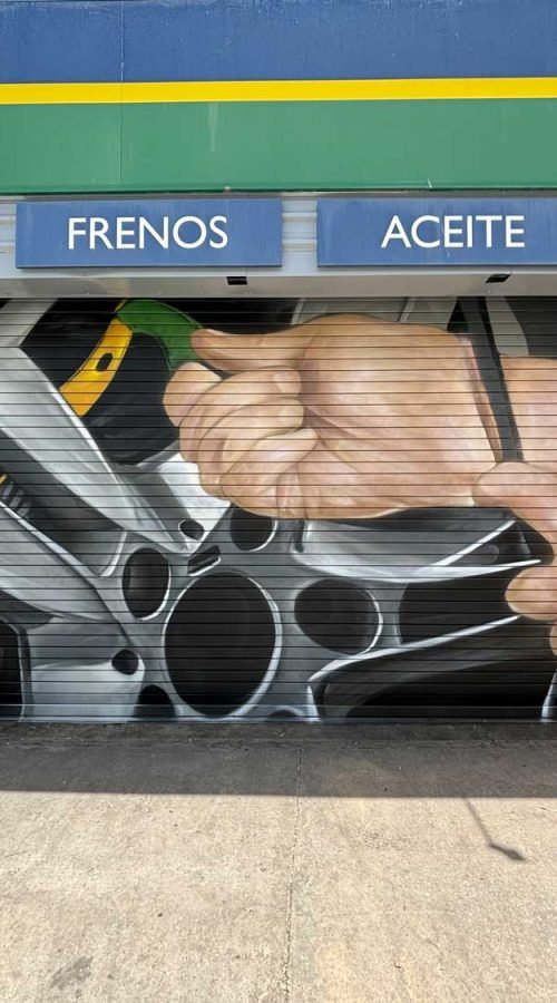 Mural de manos apretando tuerca en taller Euromaster Málaga